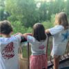 Niños mirando desde un balcón con camisetas